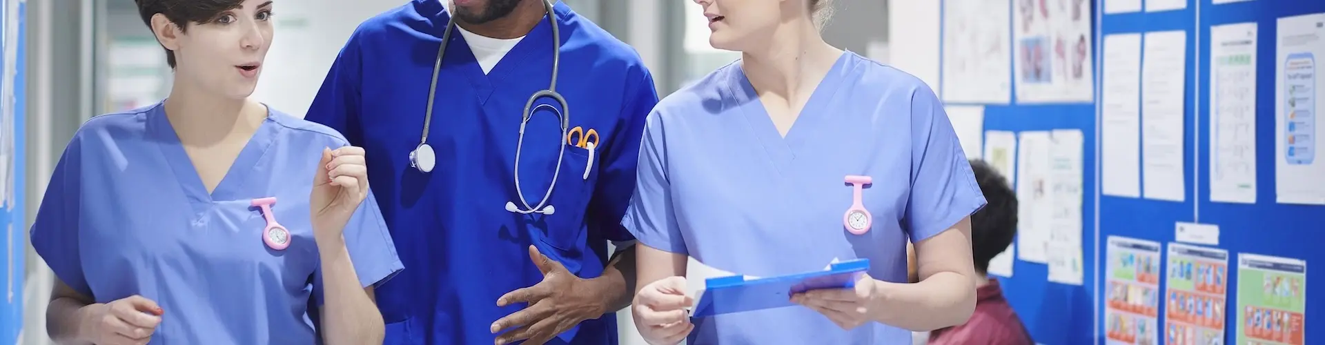 Three nurses talking in a hospital corridor