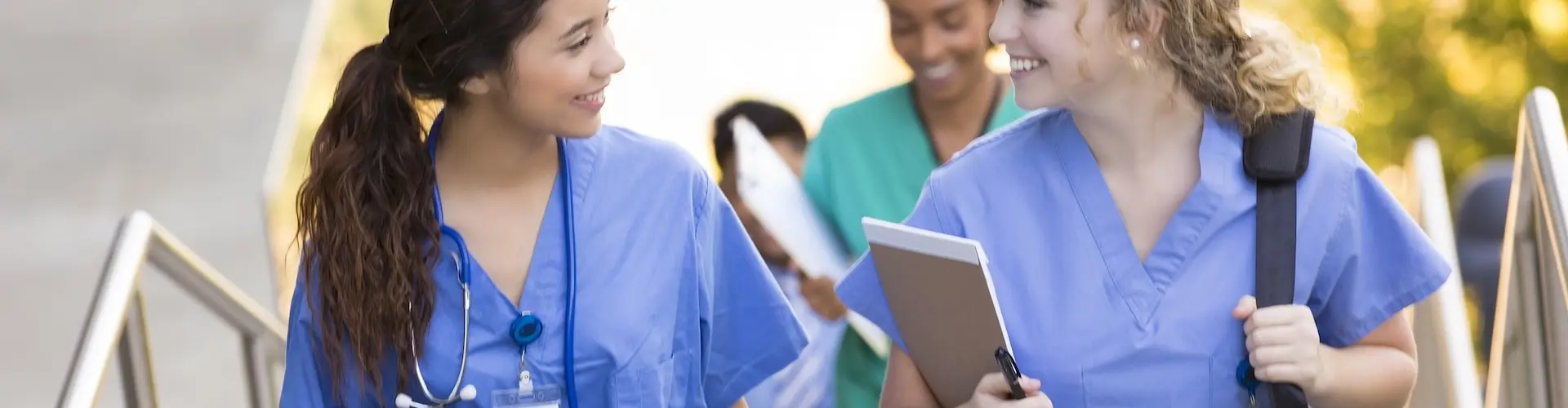Two nurses talking whilst climbing steps going to work.