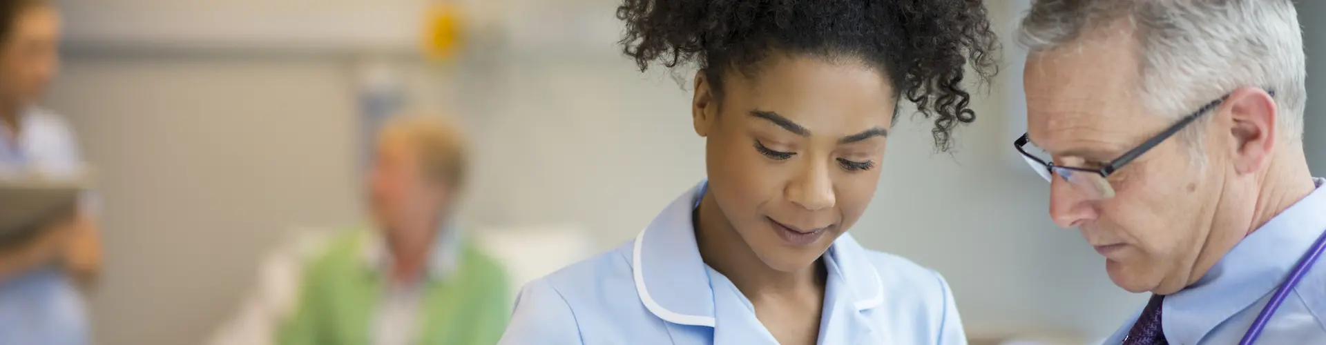 A nurse in consultation with a doctor on a ward