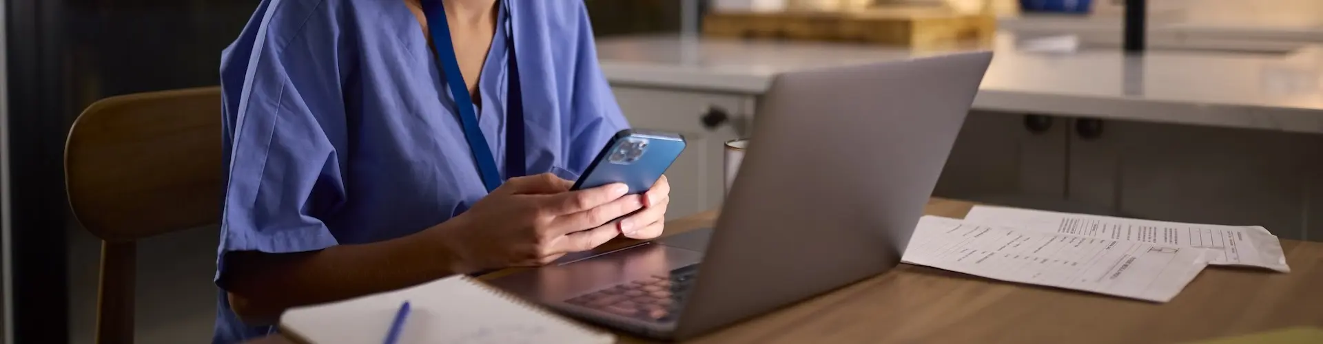 Nurse working with a phone and laptop