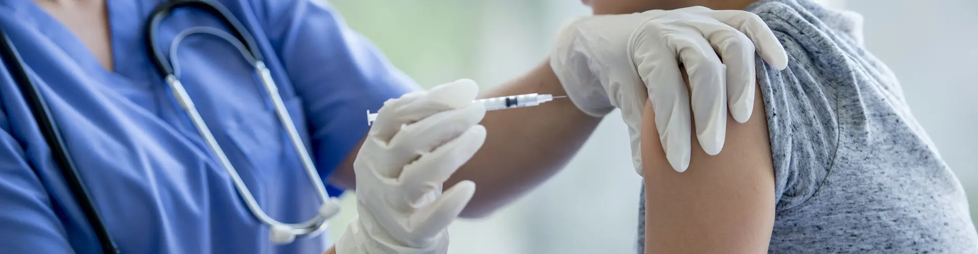 A vaccination work giving a child an immunisation injection