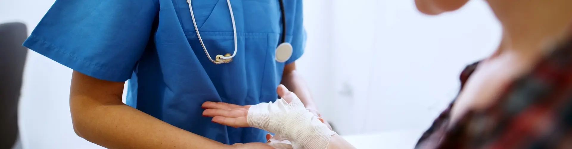 Cropped photo of an A&E nurse bandaging a patient's hand