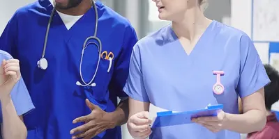 Three nurses talking in a hospital corridor