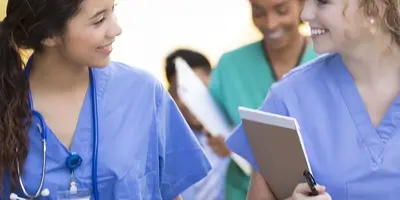 Two nurses talking whilst climbing steps going to work.