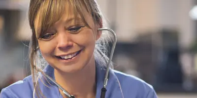 Headshot of a nurse taking a patient's blood pressure