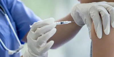 A vaccination work giving a child an immunisation injection