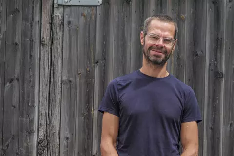 Matt Farrah standing in front of a wooden door